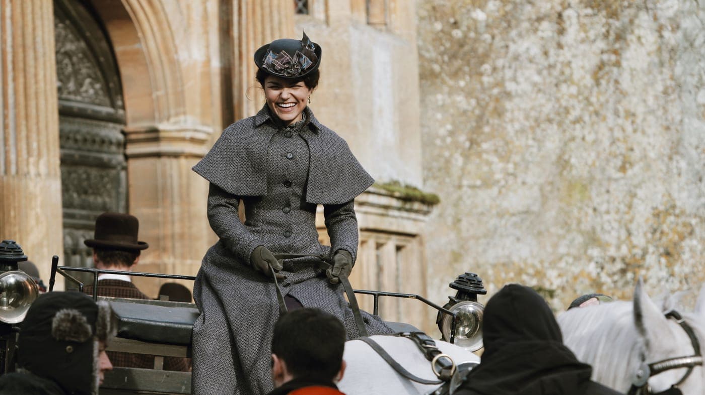 An actress in period dress on a carriage, from The Christmas Candle
